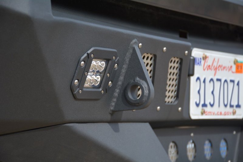Rear view of a silver Toyota Tacoma with the DV8 Offroad steel bumper, showing the textured finish and integrated LED light.